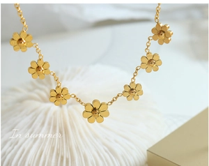 Dettaglio ravvicinato dei ciondoli a margherita placcati oro 18K e catena lucida