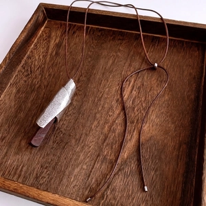 Vintage geometric metal swirl and wood pendant necklace on long brown wax cord