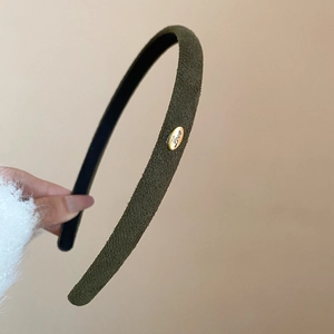 Détail du serre-tête en velours olive foncé avec plaque métallique gravée Love