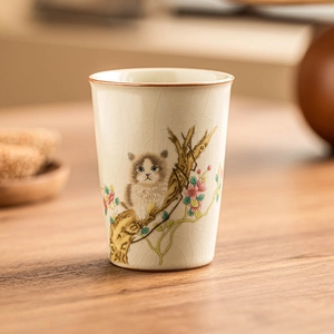 Ru-kiln ceramic teacup with hand-painted cat and flower motif on light yellow glaze