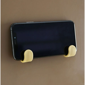 Minimalist J-style wall hooks used as a horizontal phone stand on a matte brown surface
