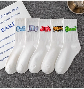 Flat lay of five white cotton mid-calf socks with colorful graffiti letter embroidery