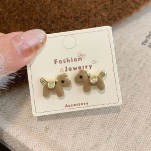 Detailed close-up of brown flocked puppy earrings with gold accents on white card