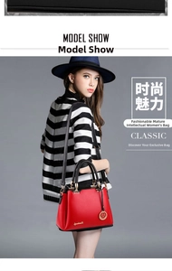 Detailed view of luxury red and black contrast leather handbag with golden metal hardware