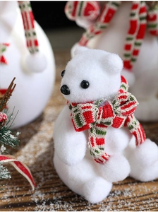 Detail of white flocked Christmas polar bear with a red and green plaid scarf texture