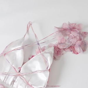 Detail van een organza jurk met 3D-bloemen en satijnen textuur op de halslijn