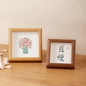 Detail of square solid wood picture frames in natural and walnut finish with art inserts