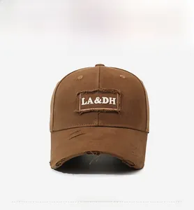 Detailed close-up of retro brown baseball cap with embroidered letters and distressed texture