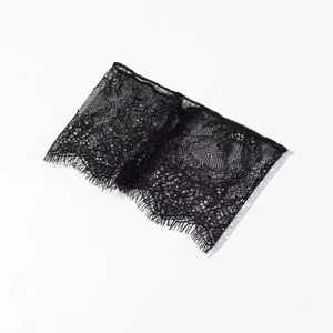 Détail du tissu en dentelle florale noire avec des bords délicats en franges de cils