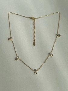 Detailed view of the 18k gold plated necklace featuring double zircon clusters and extension chain