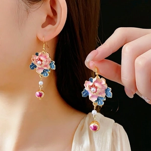 Vintage enamel flower earrings with pearls and long tassels worn by a model