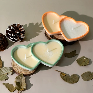 Close-up of heart-shaped scented candle cups in green and orange for DIY home decor