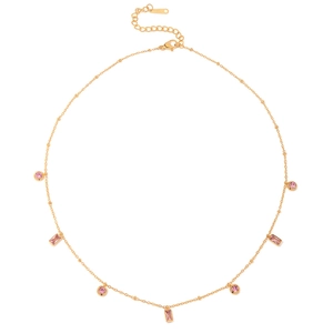 Détail macro du collier en acier doré avec des breloques en cristal rose rondes et carrées
