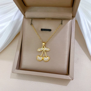 Detailed view of luxury cherry pendant necklace with cubic zirconia in a beige jewelry box