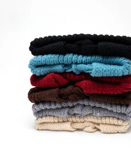 Close-up of thick chunky knit beanies in various colors showing warm wool texture