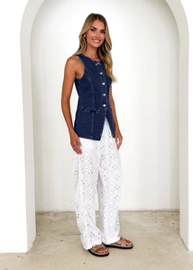 Close-up of retro dark blue denim vest paired with white lace embroidery wide-leg pants