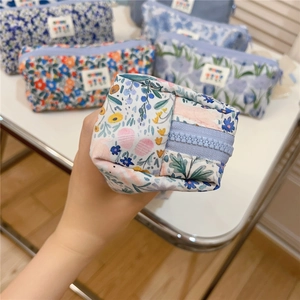 Close-up of floral canvas pencil case with zipper closure held in hand for detail
