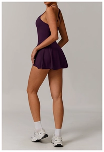 Detail of plum athletic dress featuring criss-cross back straps and a flared A-line hem