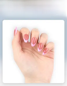 Macro view of French tip press-on nails with pink almond shape and glossy finish