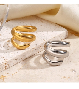 Detailed view of layered spiral open rings in gold and silver on a stone base