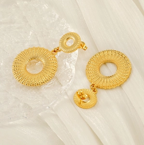 Detailed macro of 18K gold-plated titanium steel earrings with spiral woven textures