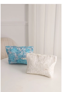 Detail view of blue and white floral jacquard makeup bags with high-quality fabric texture