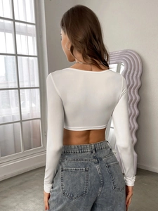 Back view of white slim fit long sleeve crop top with high stretch fabric