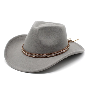 Detail of grey felt cowboy hat featuring ornate rhinestone and gold stud hatband
