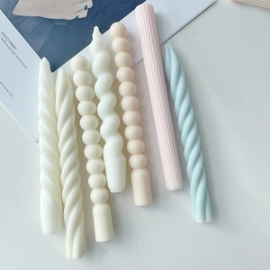 Detailed view of spiral and ribbed scented candles in soft pastel colors and matte finish