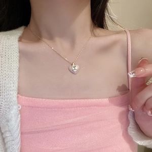 Vintage gold necklace with pink enamel heart pendant and zircon on model's neck