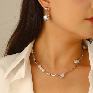 Baroque irregular pearl necklace and earrings set worn on a model with white shirt