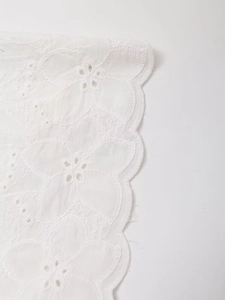 Close-up of white floral embroidery lace with scalloped edges for the blazer and shorts