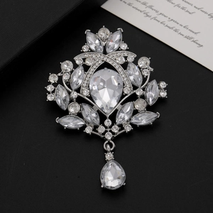 Macro shot of silver vintage crystal brooch with teardrop rhinestones on black background