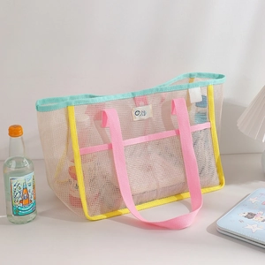 Close-up of the mesh tote bag featuring reinforced pink handles and durable seam stitching