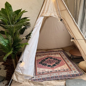 Detail of bohemian patterned cotton blanket styled inside a cozy indoor teepee tent