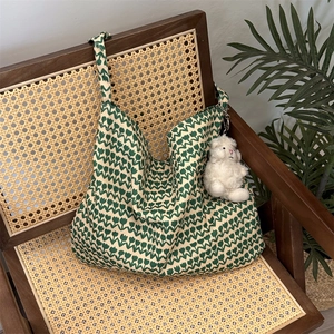 Detail shot of a green tulip floral canvas tote bag on a vintage wooden chair