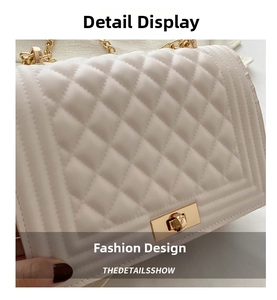 Detailed view of white quilted leather texture and gold-tone twist lock closure on the bag