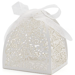 Laser-cut white wedding favor box with intricate floral hollows and silk ribbon bow