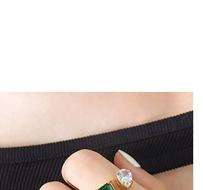 Detailed shot of double stone ring with emerald cut green gem and pear shaped zircon
