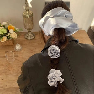 Elegant grey satin scrunchie and rose hair ties worn on a braided hairstyle