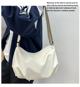 Side view of cream white pleated dumpling bag showing volume and casual crossbody style