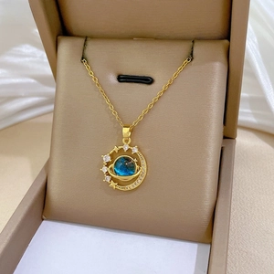 Dettaglio della collana stella e luna dorata con sfera celeste blu su porta gioie