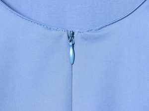 Vue détaillée d'une fermeture éclair invisible sur une chemise en popeline bleu clair