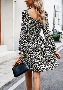 Detail of smocked back design on a floral long-sleeved dress with ruffled hem layers