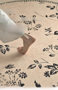 Close-up of soft beige art rug showing floral patterns and skin-friendly texture