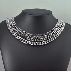 Close-up of tiered silver cuban link chains set on a black neck display stand