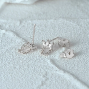 Detailed macro view of S925 sterling silver eye-shaped diamond earrings with chain tassels