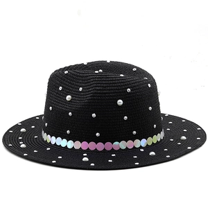Close-up of black straw hat featuring sequins, white pearls and silver rhinestones