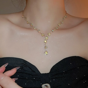Detailed view of golden Y-shaped necklace with colorful crystals on model neck