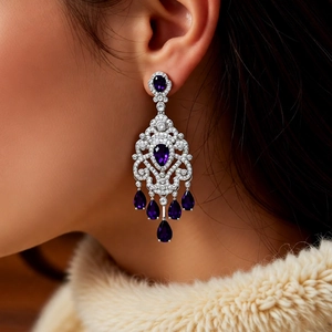 Detail of luxury flower tassel earrings featuring purple teardrop gems on silver setting